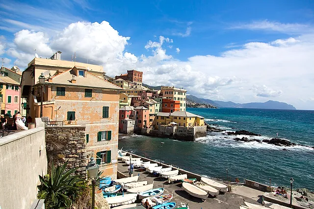 Boccadasse, the old fishing village of Genoa: pastel houses, small boats on the pebble beach and the coast beyond